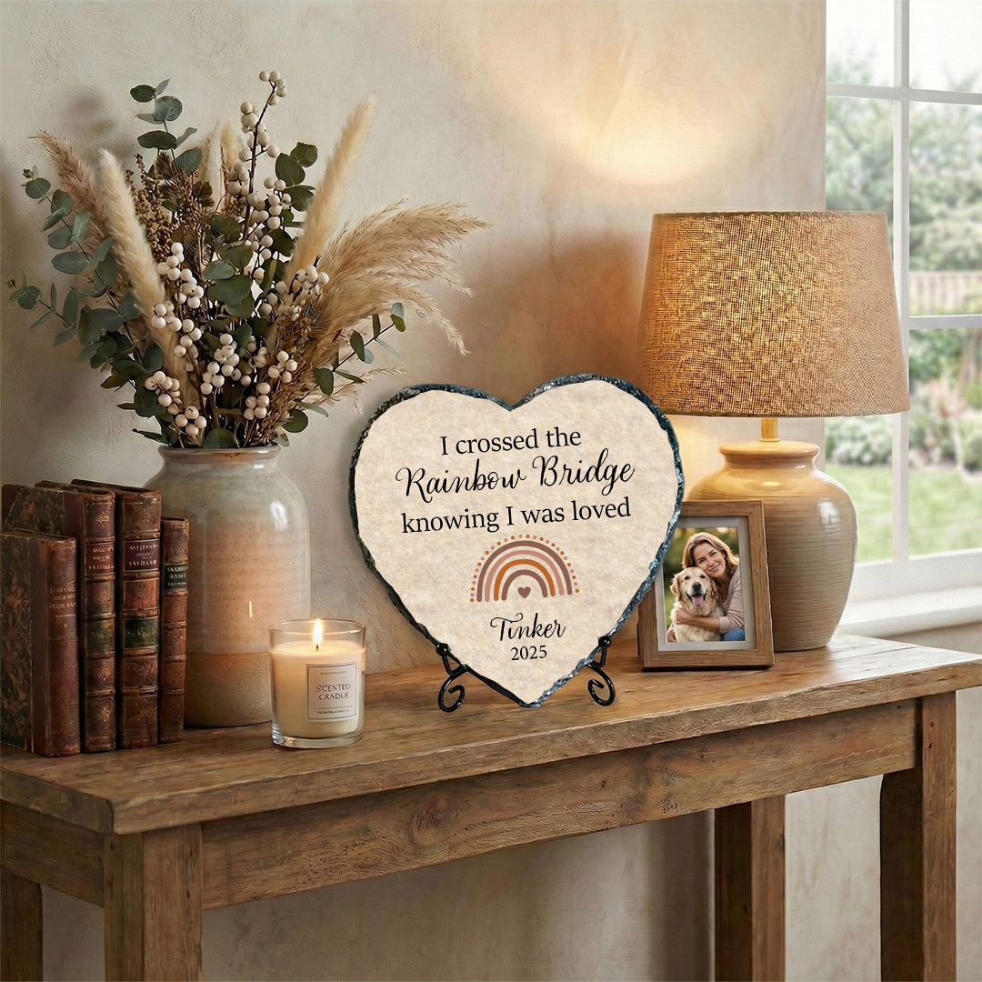 Heart-shaped plaque with text on a wooden table with decor items