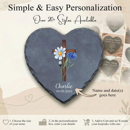 Heart-shaped slate with cross and flowers design, personalized with name and date, on a light background.