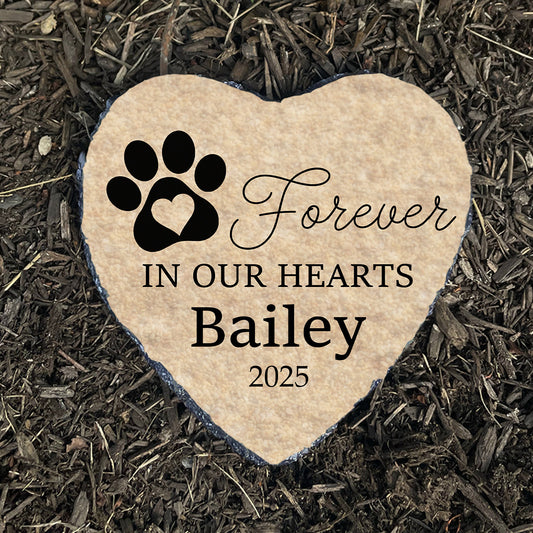 Personalized dog memorial stone on dark mulch. Beige heart with paw print. Pet grave marker. Sympathy gift for loss of dog.