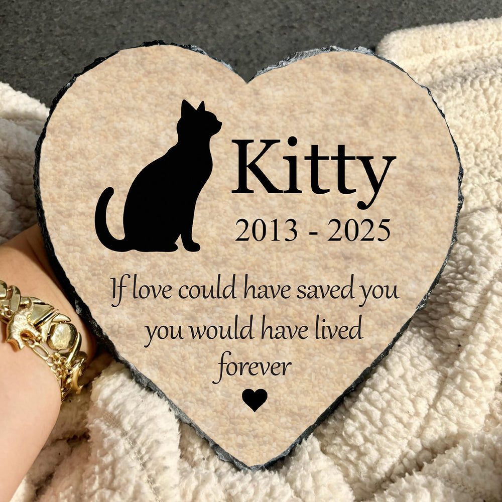 Heart-shaped plaque with a cat silhouette and text on a textured surface