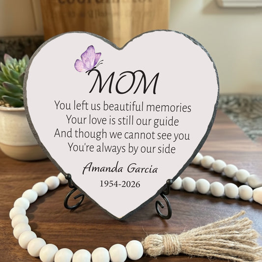 Heart-shaped plaque with a message for 'Mom' on a wooden surface with decorative elements.