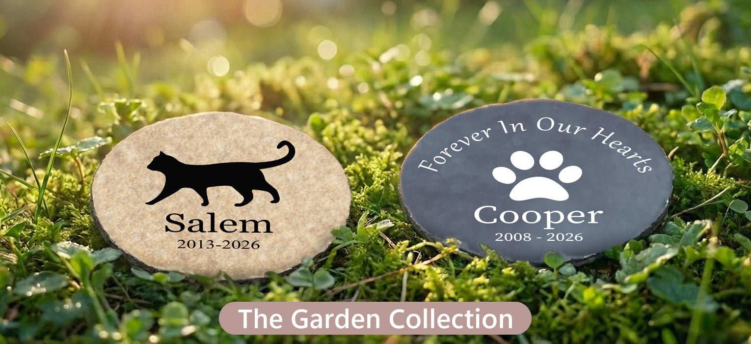 Personalized outdoor pet memorial garden stones resting on lush green moss, featuring a beige stone with a cat silhouette and a slate stone with a dog paw print.