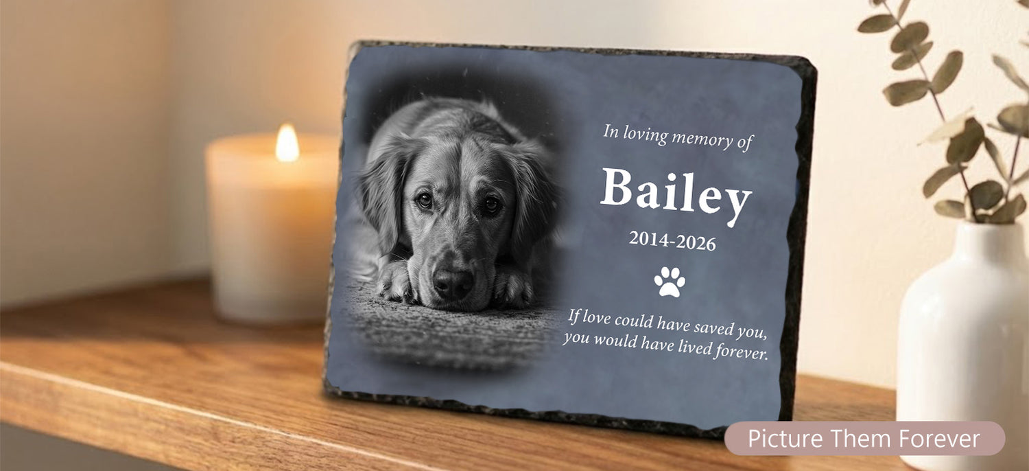 Personalized slate pet photo memorial plaque standing on a wooden shelf next to a lit candle and white vase, creating a warm indoor tribute